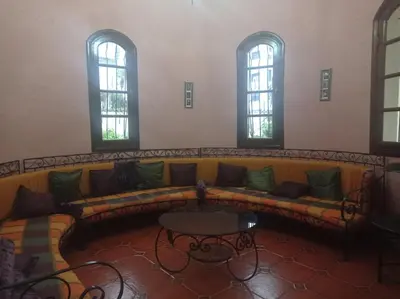 a couch in a room with a table and windows at 2 bedroom apartment and living room with small terrace in Skhirat