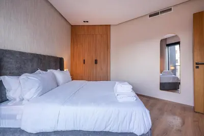 a bedroom with a large white bed with a window at Self Check In 1BR With Gym And Coworking Near CFC in Casablanca
