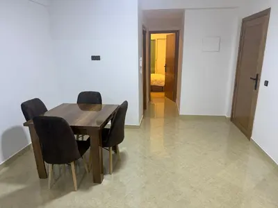 a dining room with a wooden table and black chairs at Baya Residentie in Temara