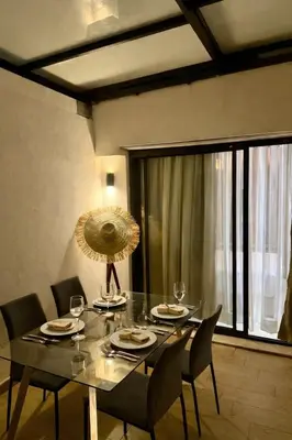 a dining room table with chairs and a large window at Cosy Loft with Sauna - City Center Casablanca in Casablanca