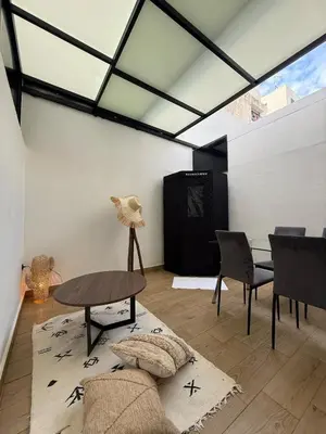 a living room with a table and chairs and a glass ceiling at Cosy Loft with Sauna - City Center Casablanca in Casablanca