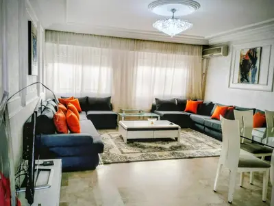 a living room with a blue couch and orange pillows at Camera a 2 minuti dal mare e la mosquee Hassan 2 in Casablanca-Port