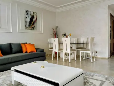 a living room with a couch and a table and chairs at Camera a 2 minuti dal mare e la mosquee Hassan 2 in Casablanca-Port