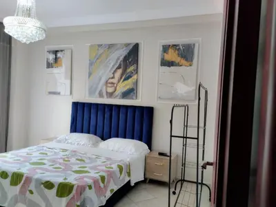 a bedroom with a bed and some pictures on the wall at Camera a 2 minuti dal mare e la mosquee Hassan 2 in Casablanca-Port
