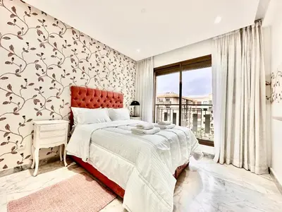 a bedroom with a large bed and a large window at Elegant apartment in Nouaceur, Close to Airport in Nouaseur