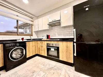 a kitchen with a washer and a dishwasher at Elegant apartment in Nouaceur, Close to Airport in Nouaseur