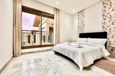 a bedroom with a bed and a large window at Elegant apartment in Nouaceur, Close to Airport in Nouaseur