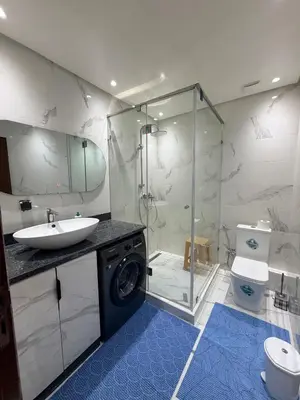 a bathroom with a shower and a sink and a washing machine at Beautiful Apartment for Rent in Corniche de Rabat in Rabat