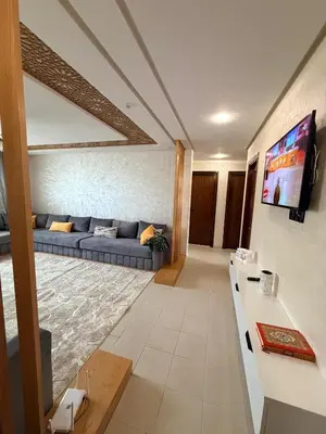 a living room with a blue couch and a tv at Beautiful Apartment for Rent in Corniche de Rabat in Rabat
