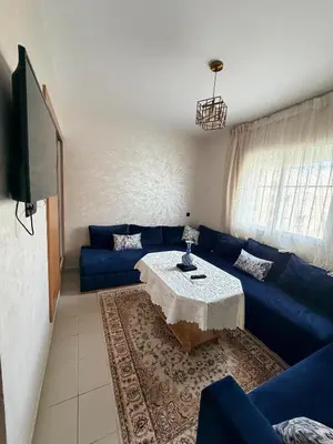 a living room with a blue couch and a table at Beautiful Apartment for Rent in Corniche de Rabat in Rabat