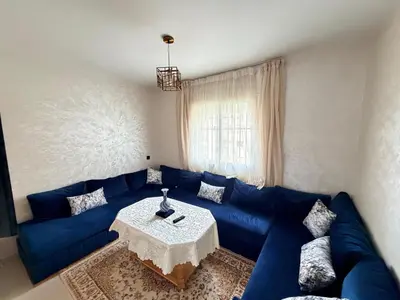 a living room with a blue couch and a table at Beautiful Apartment for Rent in Corniche de Rabat in Rabat