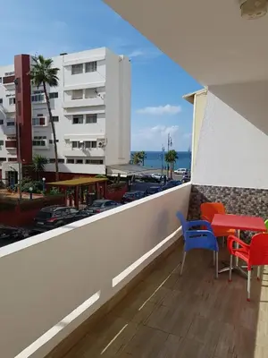 a balcony with a table and chairs and a building at Sea view Apart Rabat in Rabat