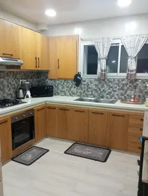 a kitchen with wooden cabinets and a sink at Sea view Apart Rabat in Rabat