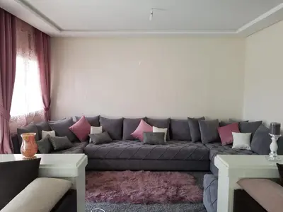 a living room with a gray couch with pink pillows at Sea view Apart Rabat in Rabat