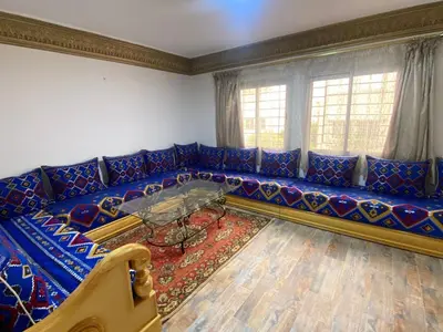 a living room with a blue couch with a glass table at Appartement idéal pour la CAN à 5 min du stade Moulay Abdellah in Rabat
