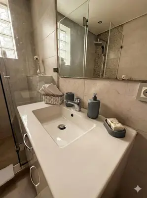 a bathroom with a sink and a mirror at Appartement cosy 2 chambres à Agdal, à 5 min de la Gare in Rabat