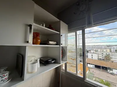 a kitchen with a window with a view of a city at Appartement cosy 2 chambres à Agdal, à 5 min de la Gare in Rabat