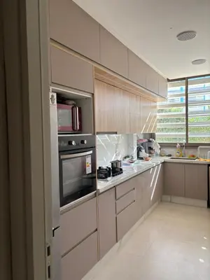 a kitchen with stainless steel appliances and wooden cabinets at Appt Mansbay beach in Mansouria