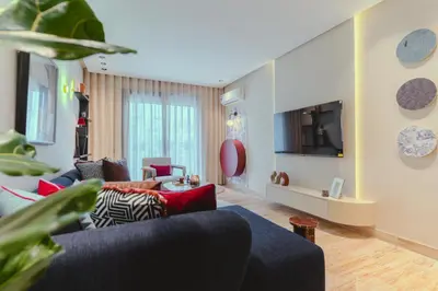 a living room with a blue couch and a tv at Marhaba Experience Appartement Luxe Belvedere in Casablanca