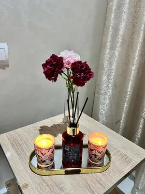 a vase with flowers and candles on a table at Studio Glamour centre ville & Casa port in Casablanca