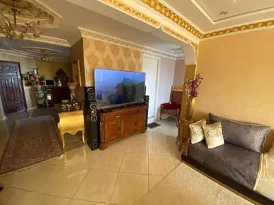 a living room with a large television and a couch at Appartement prestigieuse en plein cœur de Hay Riad et près du stade Moulay Abdallah in Rabat