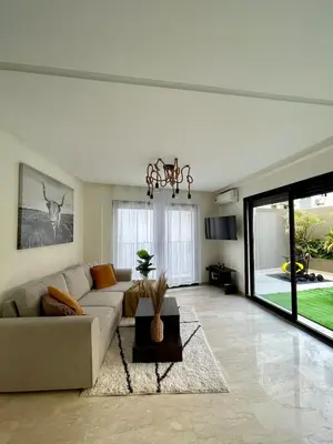 a living room with a couch and a table at Spacious Modern Apartment with Large Sunny Terrace in Central Casablanca in Casablanca