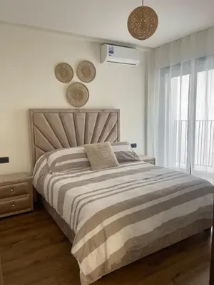 a bedroom with a large bed and two windows at Spacious Modern Apartment with Large Sunny Terrace in Central Casablanca in Casablanca