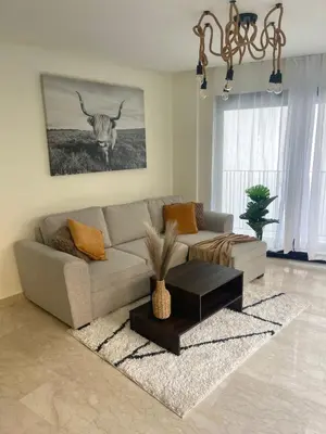a living room with a couch and a table at Spacious Modern Apartment with Large Sunny Terrace in Central Casablanca in Casablanca