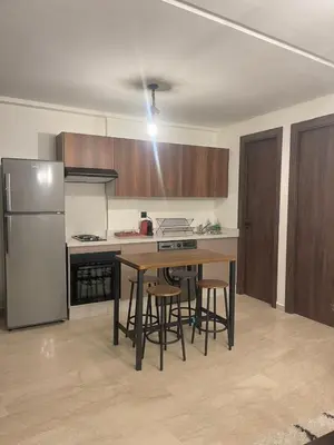 a kitchen with a table and chairs and a refrigerator at Spacious Modern Apartment with Large Sunny Terrace in Central Casablanca in Casablanca