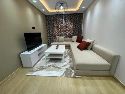 a living room with a couch and a tv at Modern Cozy Studio with Open-Plan Kitchen near All Amenities Rabat in Rabat