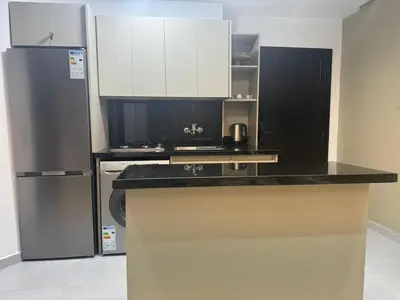 a kitchen with a black counter top and a refrigerator at Modern Cozy Studio with Open-Plan Kitchen near All Amenities Rabat in Rabat