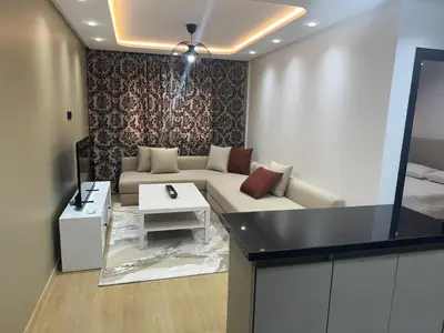 a living room with a couch and a table at Modern Cozy Studio with Open-Plan Kitchen near All Amenities Rabat in Rabat