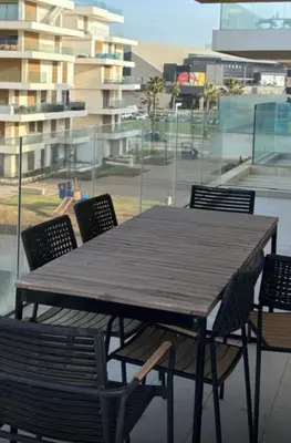 a wooden table and chairs with a view of a building at Carrousel Atlantic View in Rabat