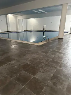 an empty room with a tile floor and a pool at Premium comfort, 150m from Val d'Or beach, 2 swimming pools in Temara