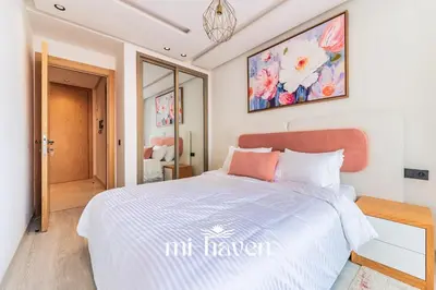 a bedroom with a white bed with a painting on the wall at Sakura - 100 Mbps Wi-Fi - Downtown Casablanca in Casablanca