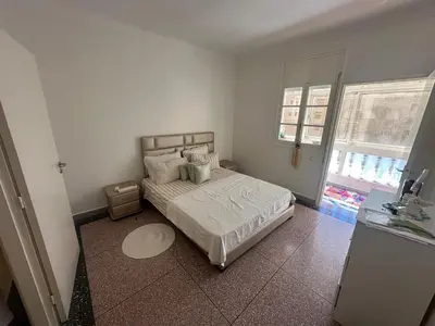 a bedroom with a bed with white sheets and pillows at Appartement 500 m from Moulay Abdellah Stadium in Temara
