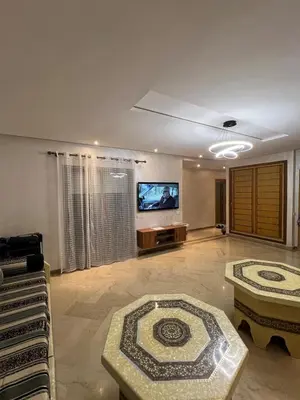 a living room with a tv and a couch and a table at Appartement en bord de Mer in Mohammedia