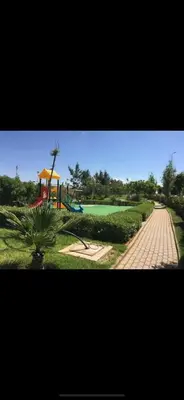 a playground in a park with a green field at Appartement en bord de Mer in Mohammedia