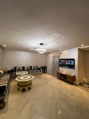 a large living room with couches and a flat screen tv at Appartement en bord de Mer in Mohammedia