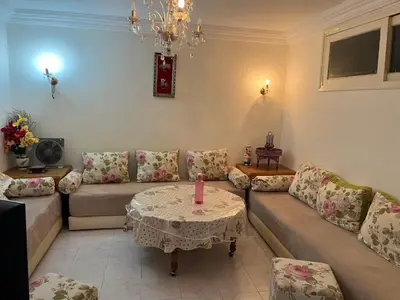 a living room with a couch and a table with a candle at Location des appartements souf in Temara