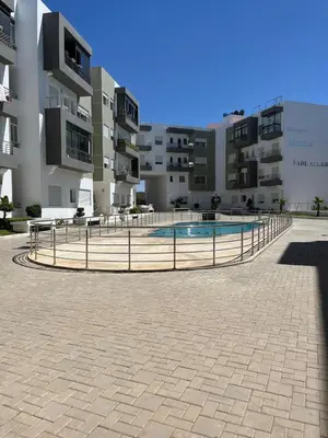 a swimming pool in front of a building at Apartment in a residence with pool in Mohammedia