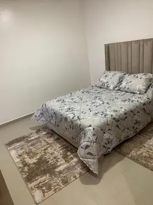 a bedroom with a bed and a rug on the floor at Apartment in a residence with pool in Mohammedia