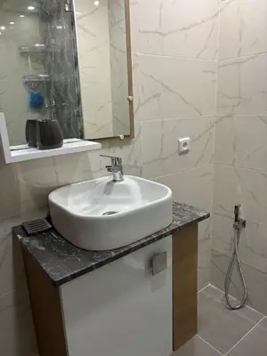 a bathroom with a white sink and a mirror at Apartment in a residence with pool in Mohammedia