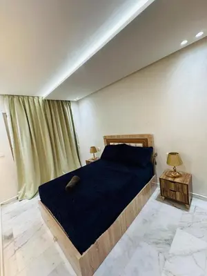 a bedroom with a bed with a blue comforter at studio bien aménagé, ambiance chaleureuse 19 in Casablanca