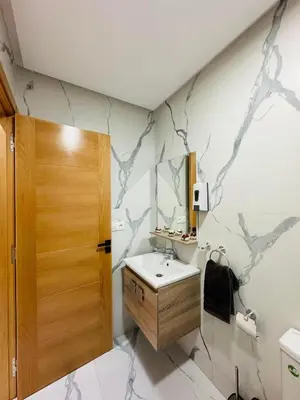 a bathroom with a sink and a wooden door at studio bien aménagé, ambiance chaleureuse 19 in Casablanca