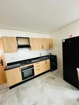 a kitchen with wooden cabinets and a black appliance at studio bien aménagé, ambiance chaleureuse 19 in Casablanca