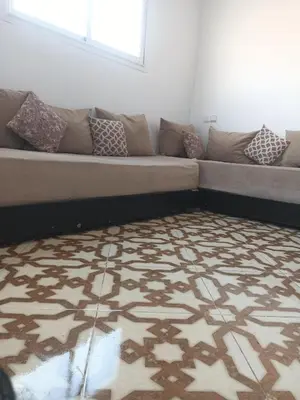 a couch in a living room with a rug at Appartement temara in Temara