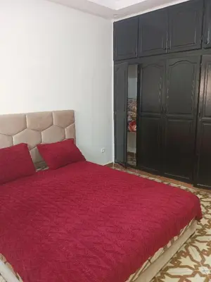 a bedroom with a large bed with a red comforter at Appartement temara in Temara