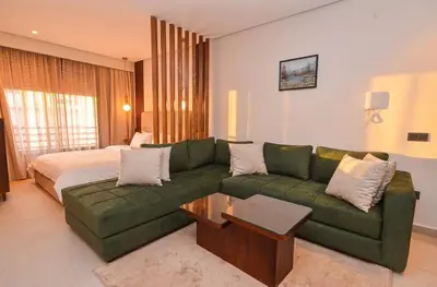 a living room with a green couch and a bed at Studio 01 Maarif - High Speed Wi-Fi in Casablanca