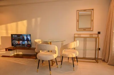 a living room with a table and chairs and a television at Studio 01 Maarif - High Speed Wi-Fi in Casablanca
